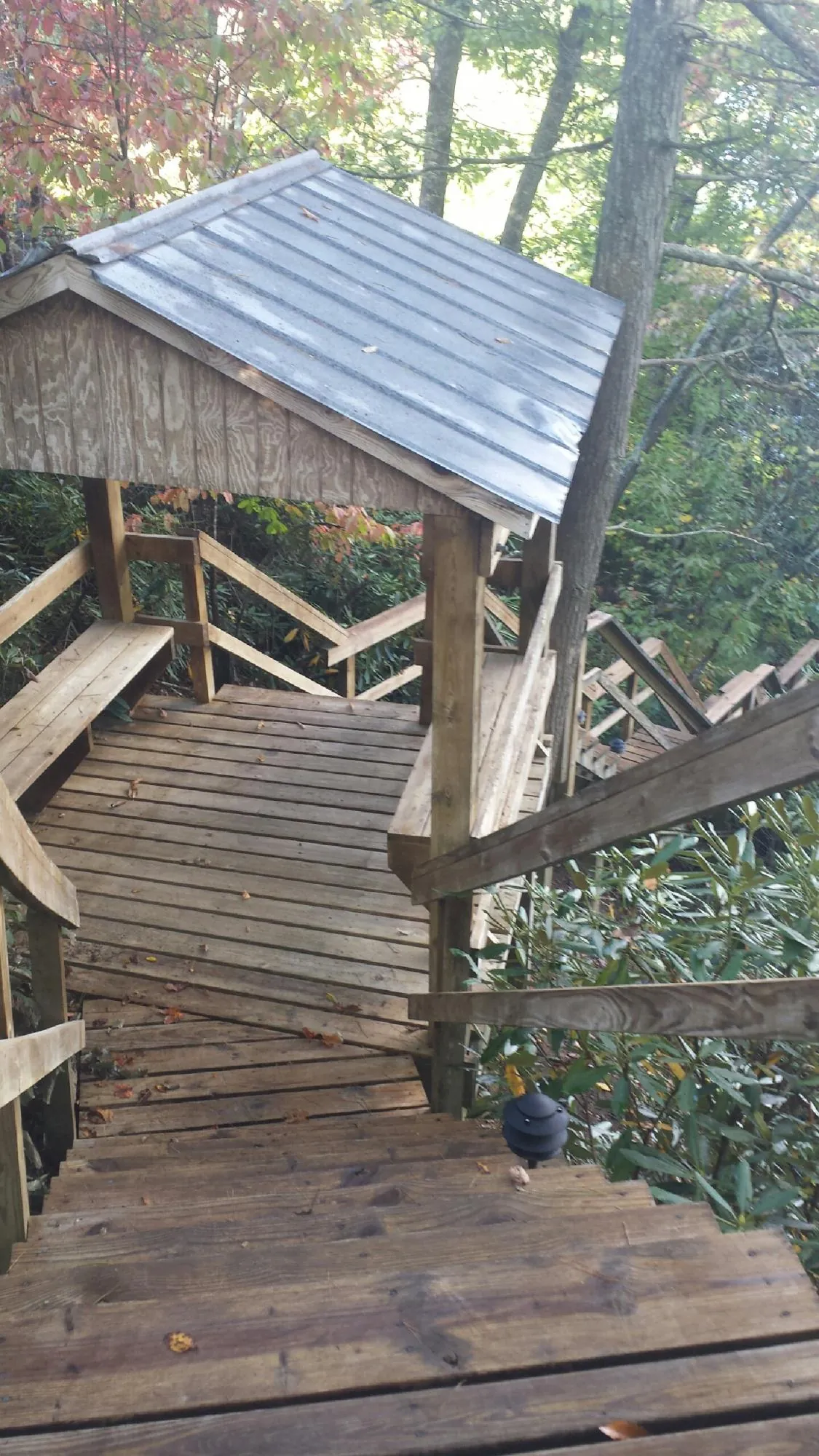 Metal roofed shelter over wooden steps on a wooded walkway — Skylight Repair & Installation work by our crew in Pleasant Valley
